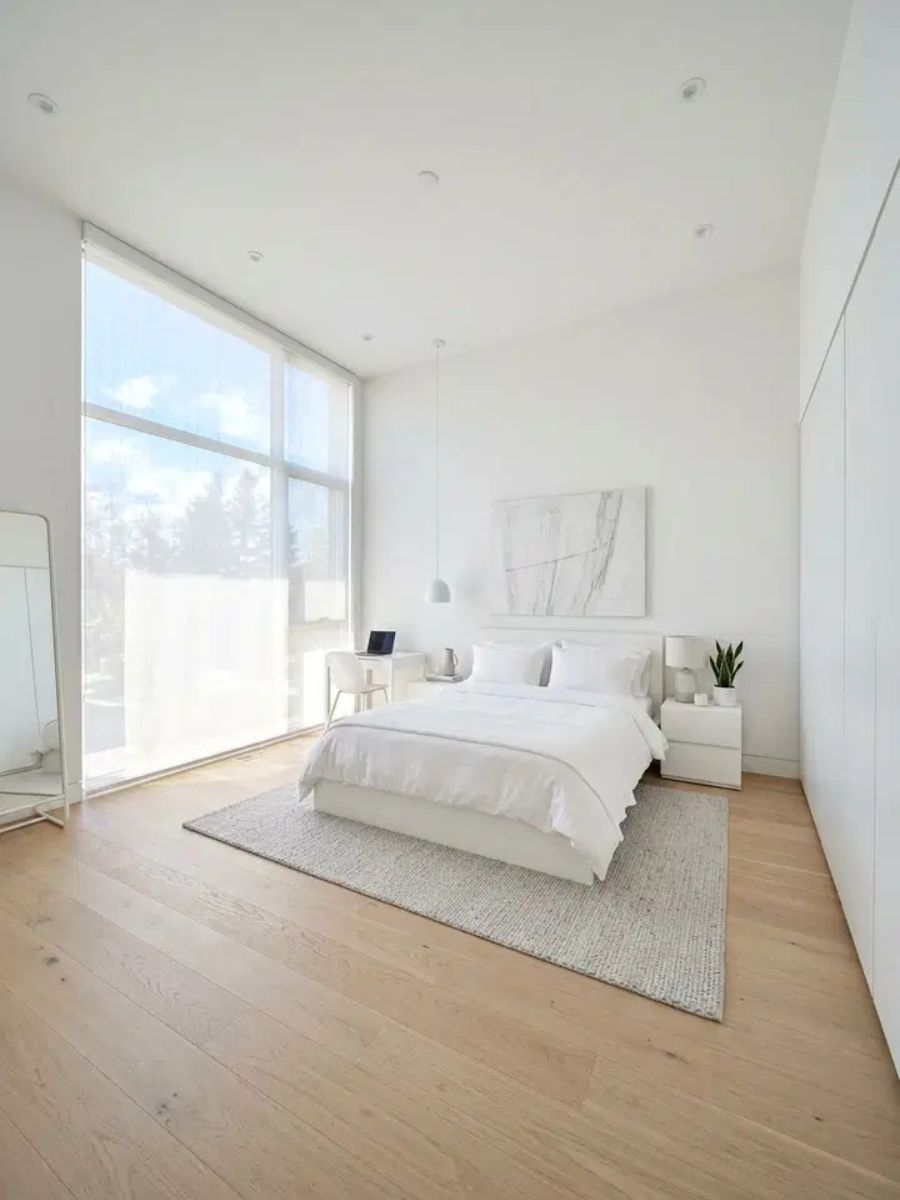 Clean minimalist white bedroom with platform bed and simple decor