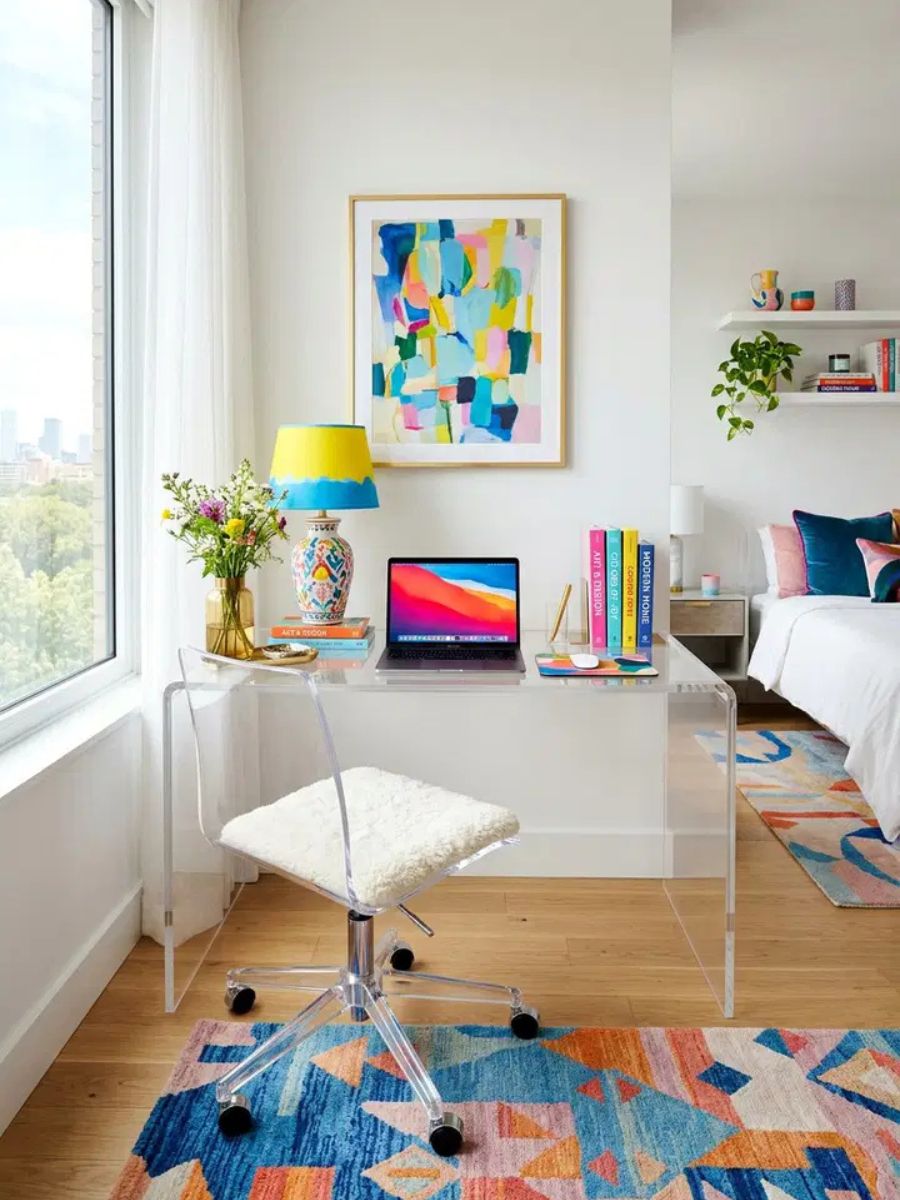 Clear acrylic ghost desk in a bedroom making the workspace nearly invisible