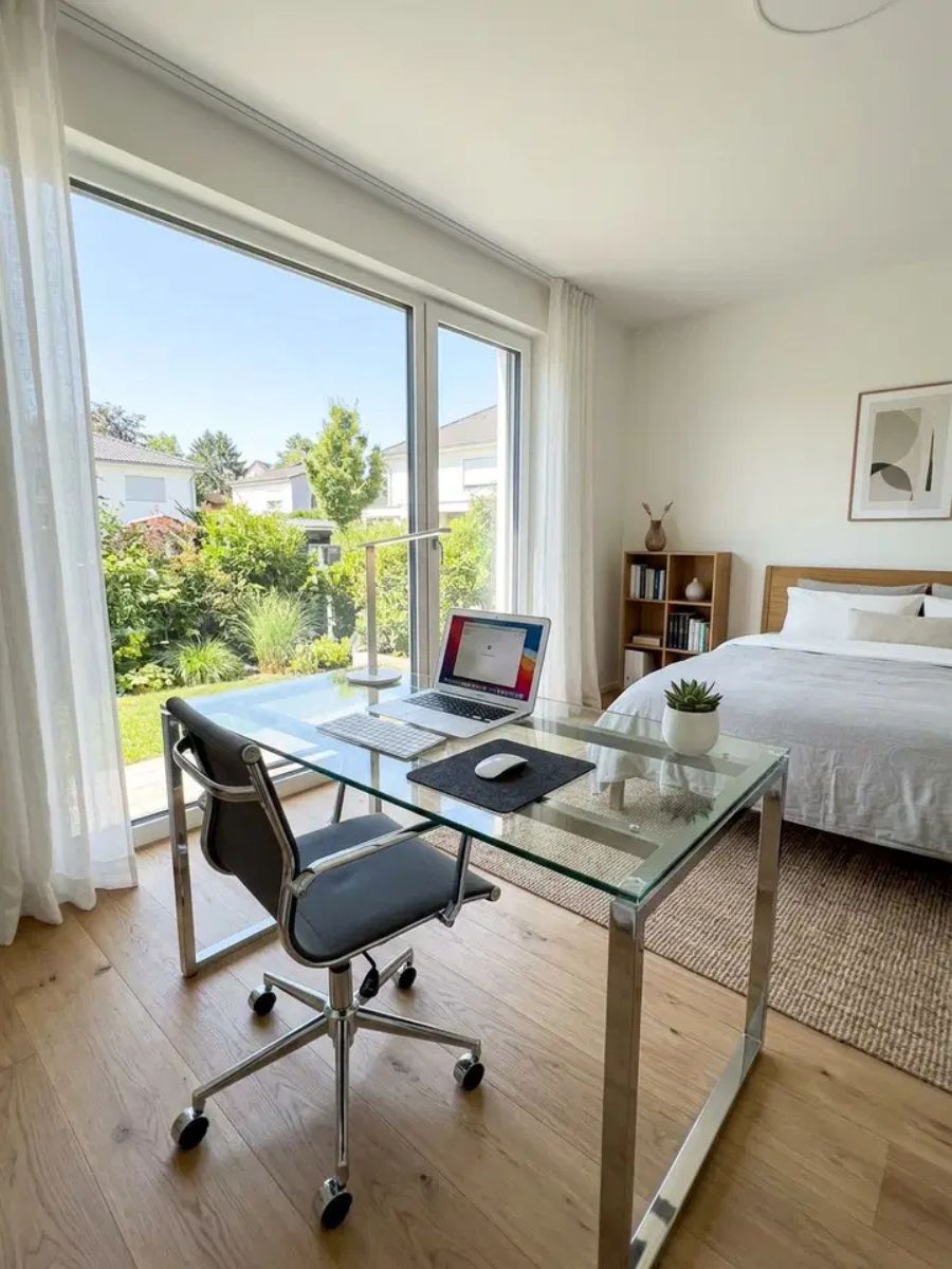 Modern glass top desk in a bedroom for a light contemporary home office setup