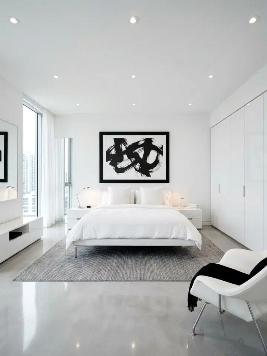 Modern white bedroom with high-contrast black accents and sleek furniture