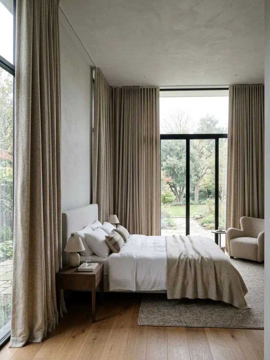 Heavy wool curtains in soft oatmeal tone providing insulation and privacy in a bedroom